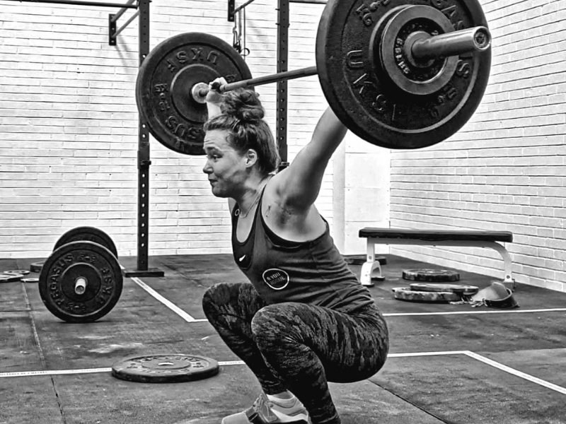 Young female athlete in the bottom of a snatch.